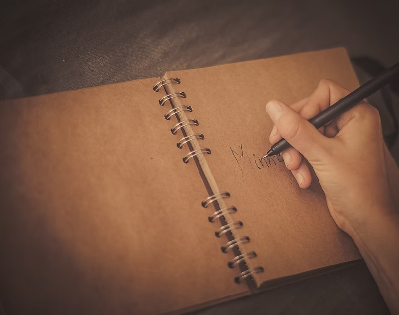 Hånd som skriver Minne i en notatbok